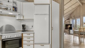 A modern kitchen with a built-in oven, a coffee maker, and a dining area with a table and chairs. - "Vivan" - 3.8km from the sea by Interhome (Rømø)