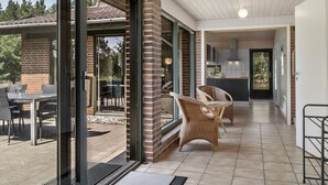 Un interior moderno con cocina, comedor y un patio con mobiliario exterior.