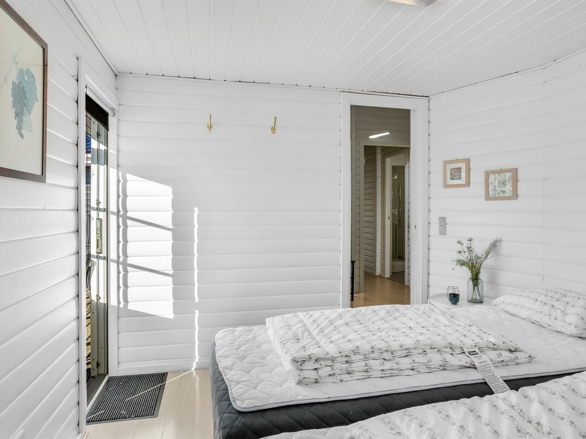 Quarto com cama, porta e janela.