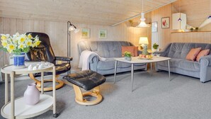 A cozy living room with a grey sofa, a round coffee table, a black leather chair, and a small side table with a vase of flowers. - "Runulf" - 2.9km from the sea by Interhome (Rømø)