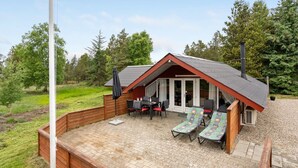A cozy cabin with a wooden deck, a dining area, and a lounge with two chairs and a table. - "Runulf" - 2.9km from the sea by Interhome (Rømø)