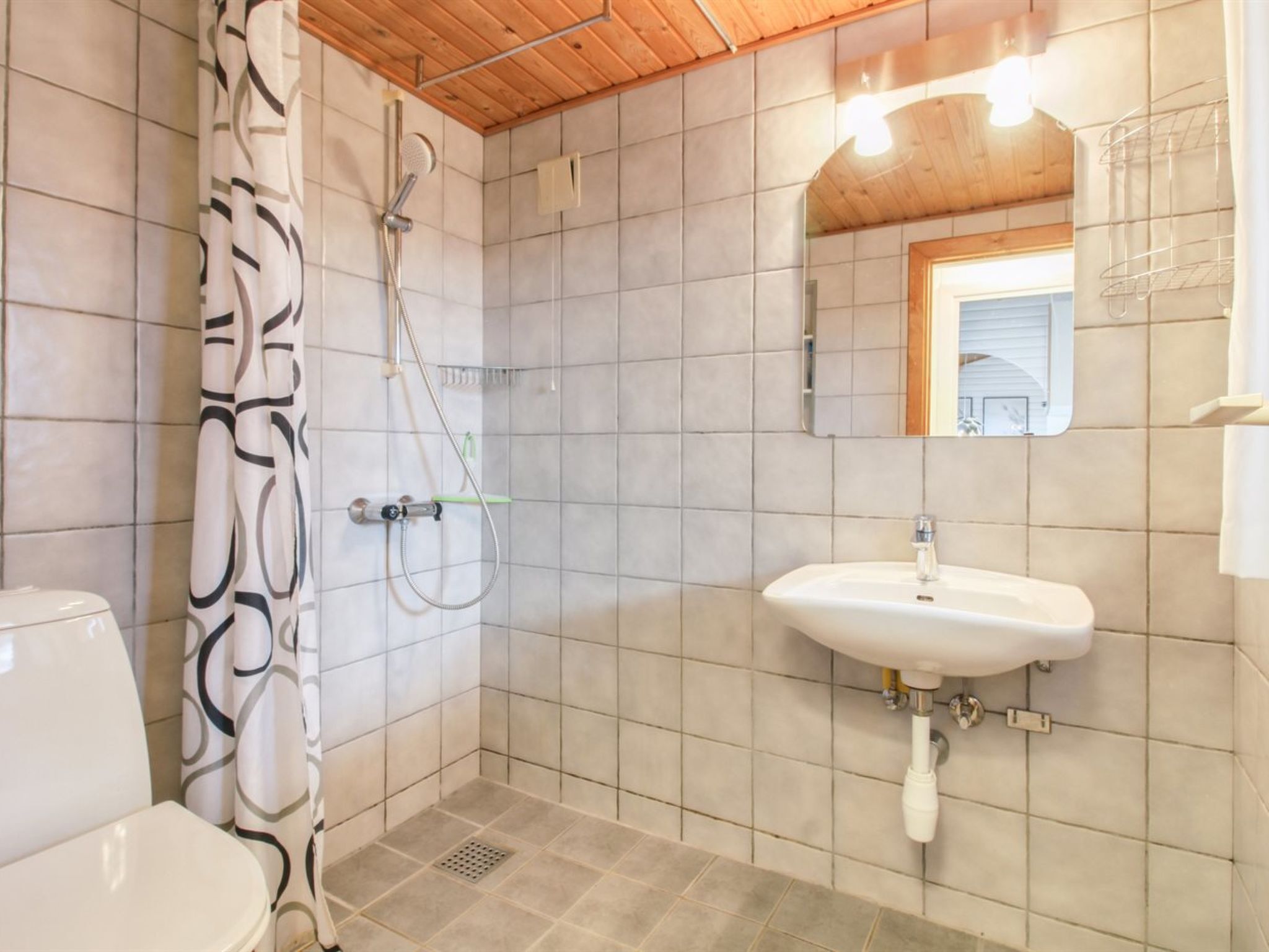 A bathroom with a shower, toilet, and sink.