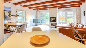 A spacious living area with a wooden ceiling, a fireplace, a dining table, and a sofa. - "Risto" - 2.3km from the sea by Interhome (Rømø)
