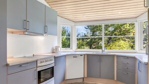 Een moderne keuken met grijze kastjes, een ingebouwde oven en een vaatwasser.