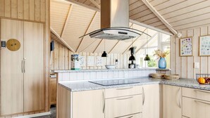 Een moderne keuken met houten kastjes, een granieten werkblad en een groot eiland.