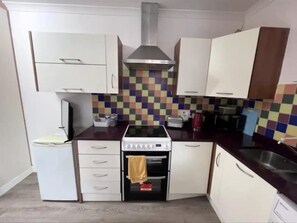 Enjoy cooking in this well-equipped kitchen with an oven, microwave, and stainless steel range hood.