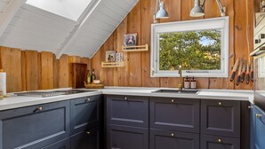 A kitchen with dark cabinets, a window, and a skylight. - "Magga" - 3.2km from the sea by Interhome (Rømø)