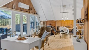 A cozy, well-lit room with a dining area, a large window, and a rustic wooden ceiling. - "Magga" - 3.2km from the sea by Interhome (Rømø)