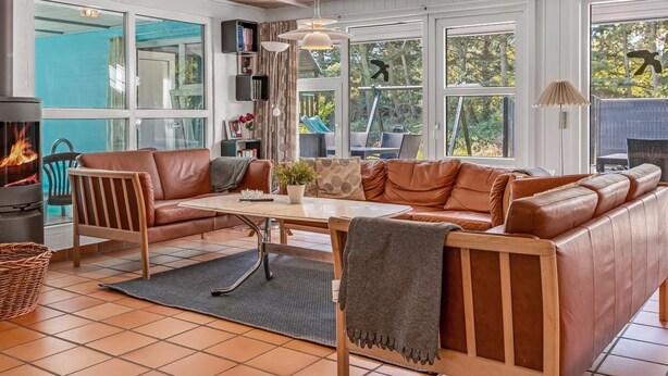 Una sala de estar acogedora con un sofá de cuero, una mesa de comedor y una chimenea.