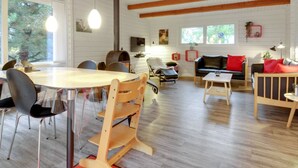Ein großzügiger Wohnbereich mit Holzboden, einem Esstisch mit Stühlen, einer Couch und einem Couchtisch.