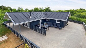 Un bâtiment moderne doté d’un toit en pente et d’un patio couvert.