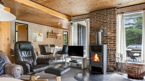 A cozy living room with a fireplace, leather furniture, and a dining area. - "Falki" - 2.5km from the sea by Interhome (Rømø)