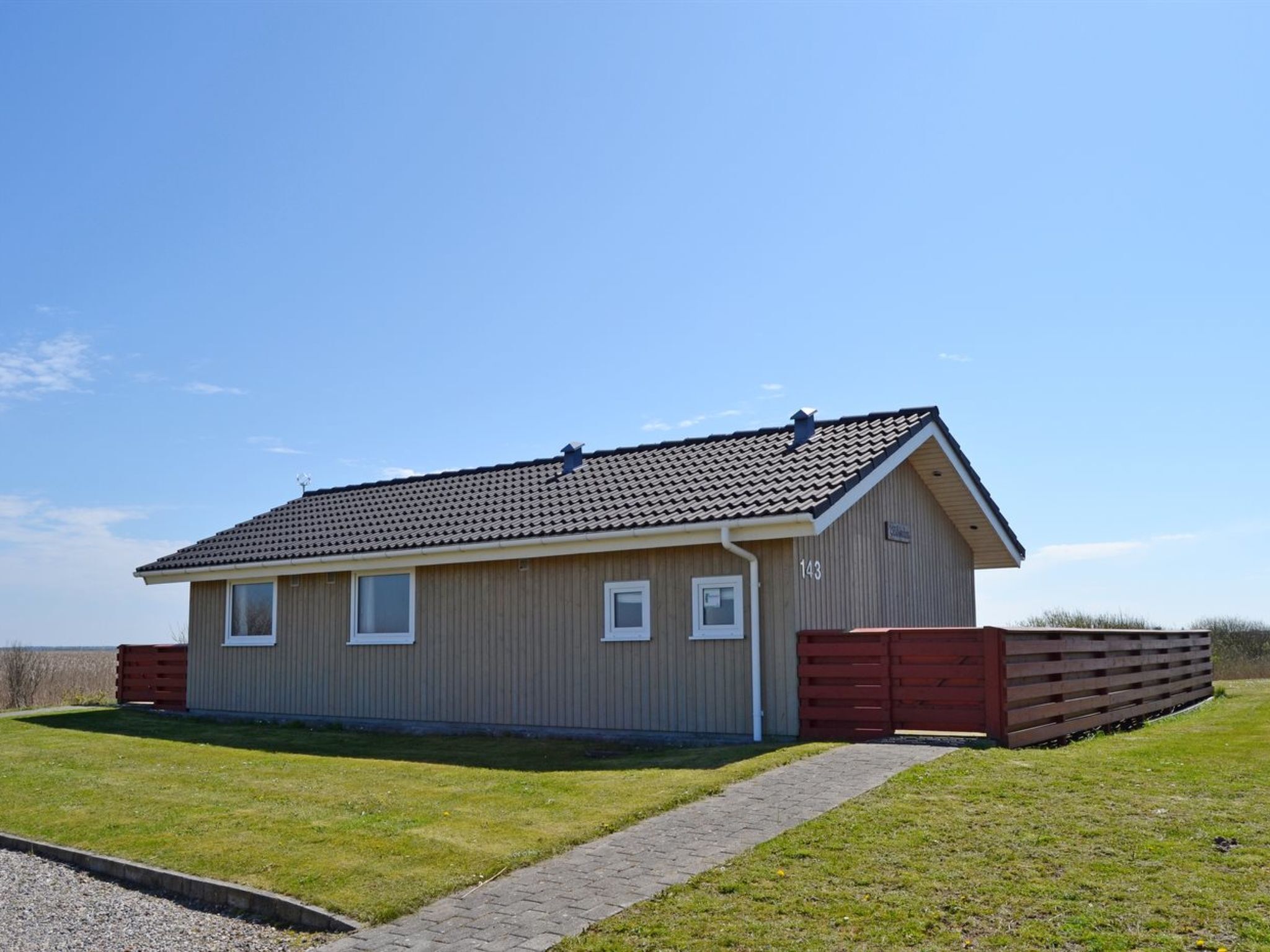 En enplansbyggnad med ett tak täckt av takpannor, en liten veranda och siffran ’143’ på sidan.