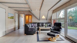 A modern living room with a sectional sofa, a coffee table, and a leather armchair.