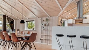 A modern kitchen with wooden beams, a central island with stools, and a dining area with chairs and a table. - "Sakulfuer" - 2.5km from the sea by Interhome (Rømø)