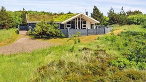 A single-story house with a sloped roof, a fenced yard, and a gravel driveway. - "Sakulfuer" - 2.5km from the sea by Interhome (Rømø)