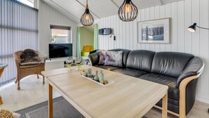 A modern living room with a leather sofa, wooden coffee table, and two pendant lights. - "Freek" - 400m from the sea by Interhome (Rømø)