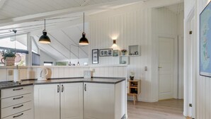 A modern kitchen with white cabinetry, a dark countertop, and pendant lighting. - "Freek" - 400m from the sea by Interhome (Rømø)
