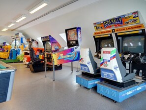 Una hilera de juegos de carreras de arcade con un letrero que dice 'SEGA RALLY'.