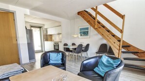 A modern living room with a wooden table, leather sofas, and a staircase. - "Arna" - 2.3km from the sea by Interhome (Rømø)