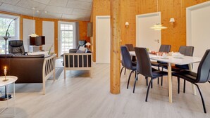 Een modern interieur met een eethoek, een bank en een televisie.