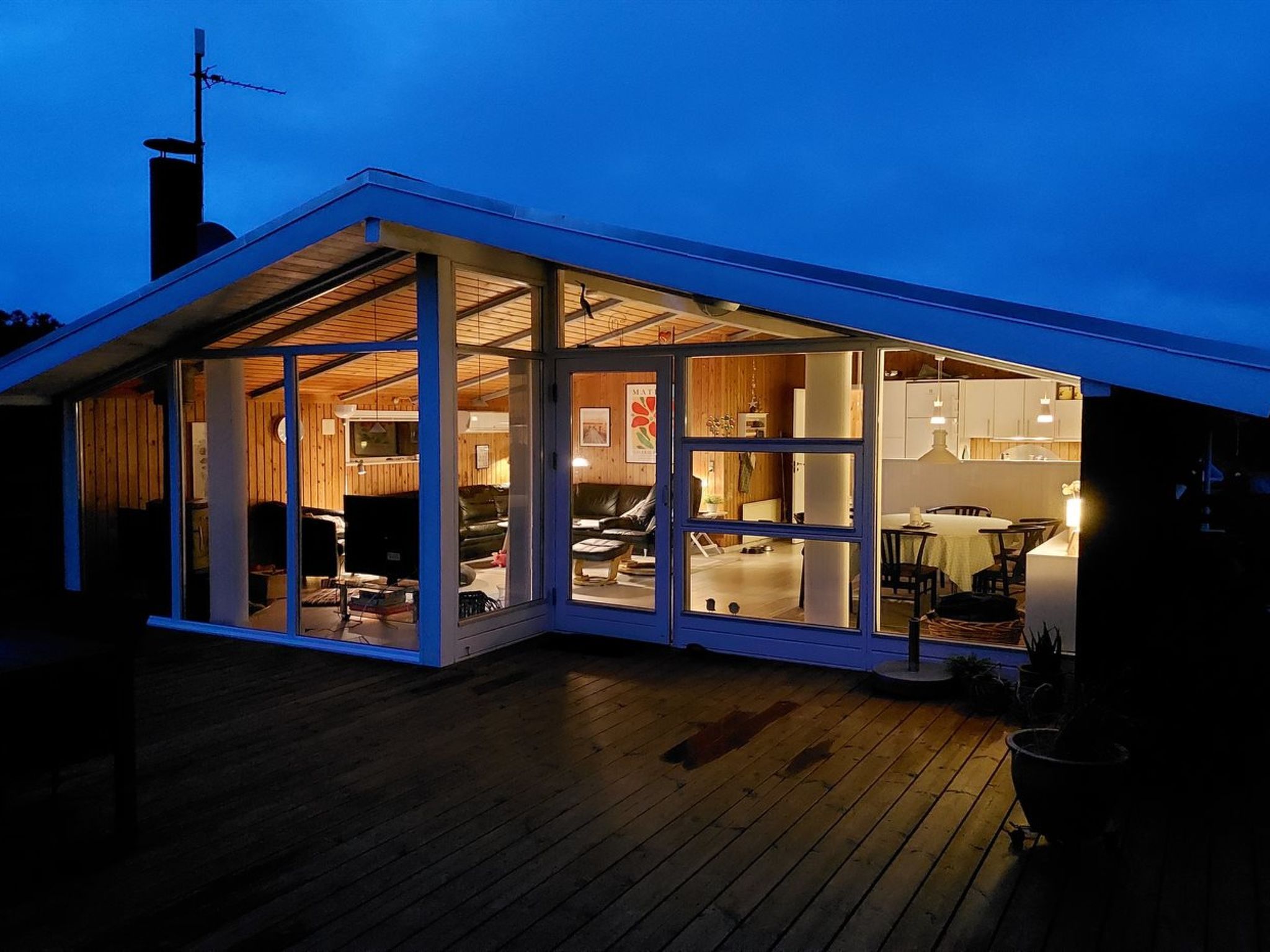 A modern house with a large glass door leading to an interior space.