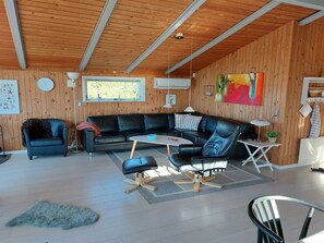 A modern living room with a sectional sofa, a small round table, and a black leather chair.
