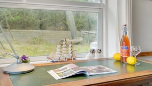 Een bureau met een model schip, drank, citroenen en een glas.