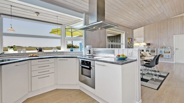 A modern kitchen with a large island, stainless steel appliances, and a view of the outdoors. - "Chrisse" - 550m from the sea by Interhome (Rømø)