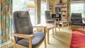 A cozy living room with a sofa, two armchairs, a small table, a TV, and a bookshelf. - "Helline" - 900m from the sea by Interhome (Rømø)