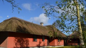 A traditional thatched-roof building with a red exterior, surrounded by a well-maintained lawn and trees. - "Helline" - 900m from the sea by Interhome (Rømø)