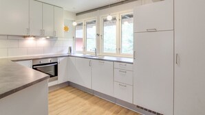 A modern kitchen with white cabinets, a wooden countertop, a built-in oven, and a window with a view of greenery. - "Helline" - 900m from the sea by Interhome (Rømø)