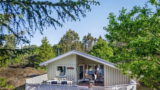 Een chalet met terras, een overdekte veranda en een klein buitenkeuken.