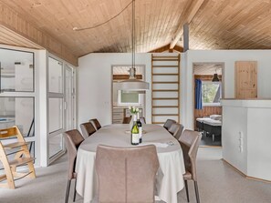Et moderne spiseområde med et rundt bord, stole og en hængende lampe.