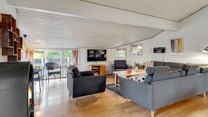 A spacious living area with a fireplace, a sofa, a TV, and a dining area with a table and chairs. - "Asdis" - 2.8km from the sea by Interhome (Rømø)