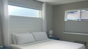 A bedroom with a bed, a nightstand, a window with blinds, and a ceiling light. - Modern, pet-friendly stay centrally located, minutes to everything in Bend! (Bend)