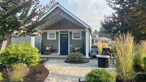 A small, single-story house with a front porch, a small garden, and a hot tub. - Modern, pet-friendly stay centrally located, minutes to everything in Bend! (Bend)