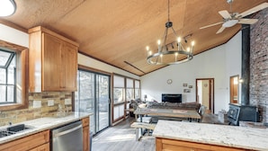 A spacious kitchen with wooden cabinets, a dishwasher, and a large island. - Deck & Gas Grill: Secluded Arnold Cabin Rental! (Arnold)