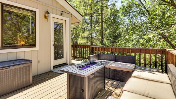 A deck with outdoor seating and a built-in grill. - Deck & Gas Grill: Secluded Arnold Cabin Rental! (Arnold)