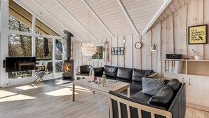 A modern living room with a fireplace, leather sofa, and a dining area. - "Germaine" - 1.2km from the sea by Interhome (Fanø)
