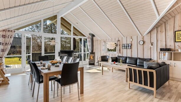 A spacious living area with a high ceiling, large windows, a fireplace, and a cozy seating area. - "Germaine" - 1.2km from the sea by Interhome (Fanø)