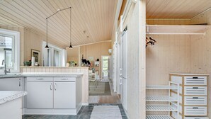 Une cuisine moderne avec des armoires blanches, un plan de travail en granit et un plafond en bois.