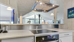 A modern kitchen with stainless steel appliances, white cabinetry, and pendant lighting.