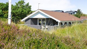 A coastal house with a sloped roof, a covered porch, and a small deck with chairs. - "Igilfar" - 700m from the sea by Interhome (Vejers Strand)