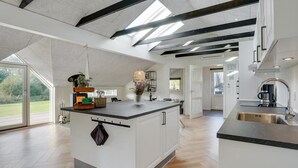 A spacious kitchen with a large island, modern appliances, and a view of the outdoors.