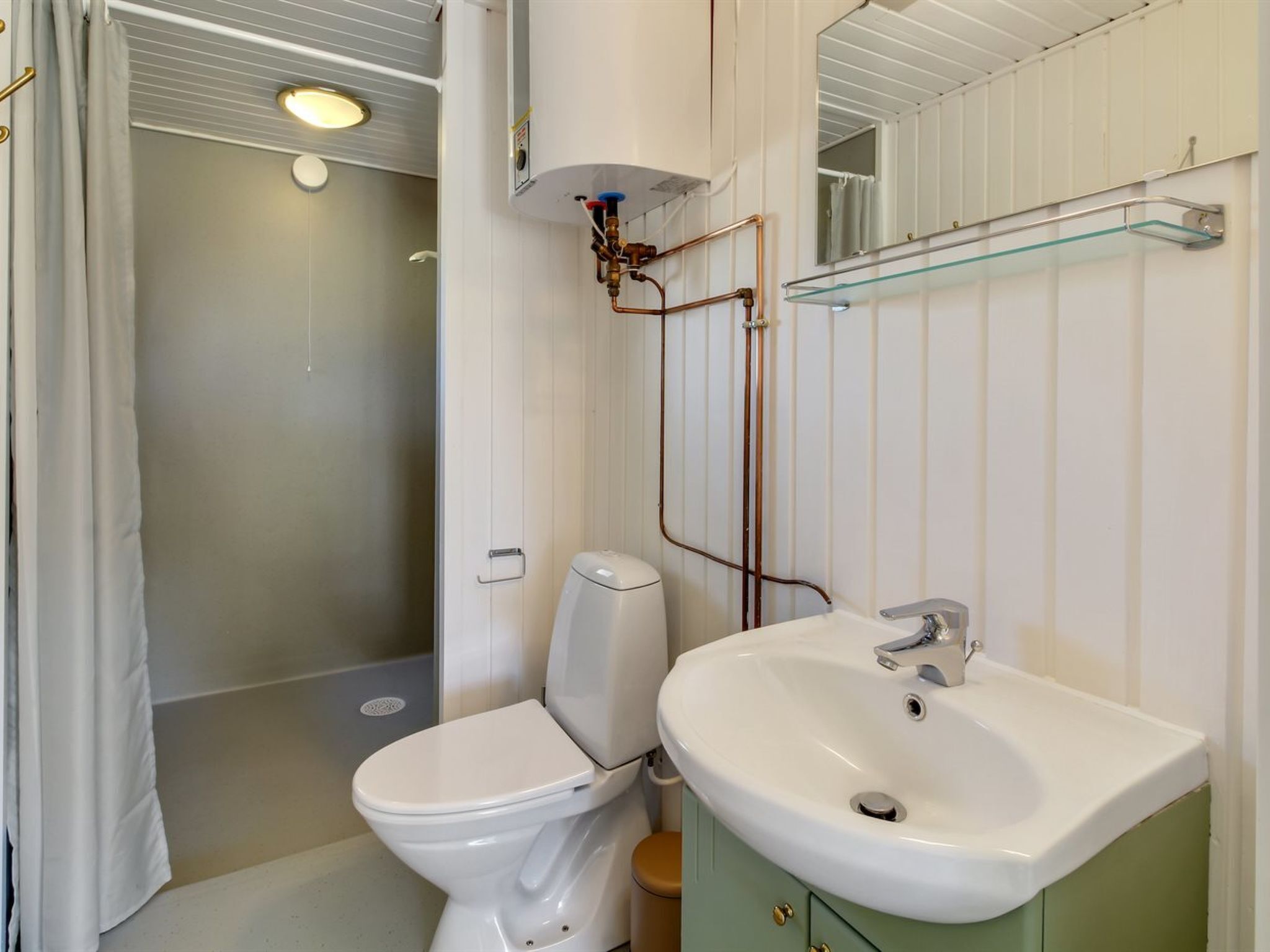 Un baño con inodoro, lavamanos y ducha.