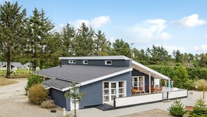 A modern two-story house with a covered porch and a small deck.