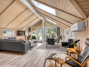 A spacious loft-style room with a high ceiling, wooden beams, a large dining table, and a cozy seating area with a sofa and chairs. - "Anisette" - 1km from the sea by Interhome (Vejers Strand)