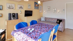 A cozy room with a wooden ceiling, a dining table with chairs, a sofa, and a TV on the wall. - "Genadij" - 1km from the sea by Interhome (Vejers Strand)