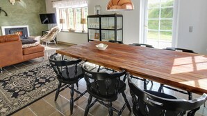 A spacious living room with a large wooden dining table, black chairs, a fireplace, a television, and a glass cabinet. - "Lioba" - 400m from the sea by Interhome (Vejers Strand)